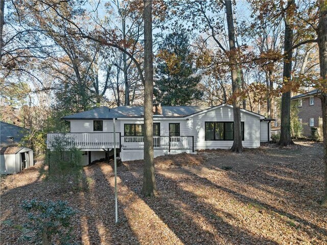 view of front of house featuring a storage shed and a wooden deck