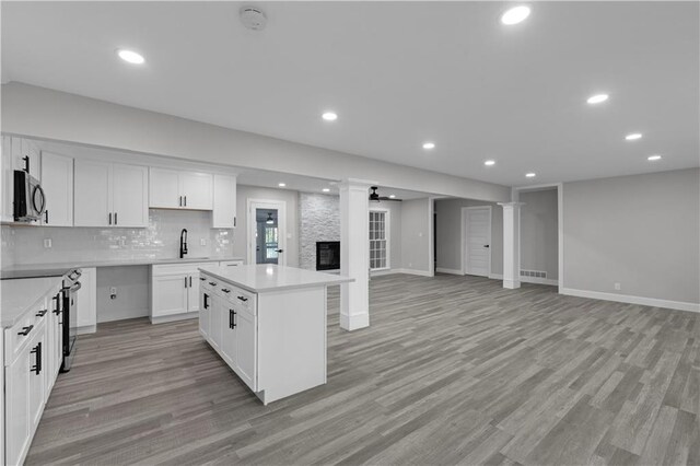 kitchen featuring white cabinetry, a center island, stainless steel appliances, and light hardwood / wood-style flooring