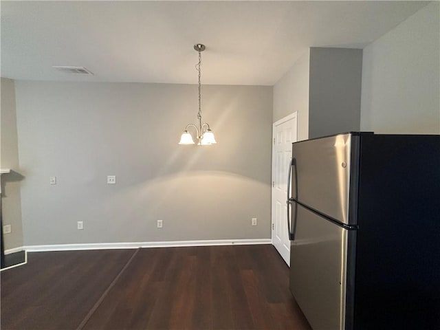 kitchen featuring decorative light fixtures, dark hardwood / wood-style floors, stainless steel refrigerator, and a notable chandelier