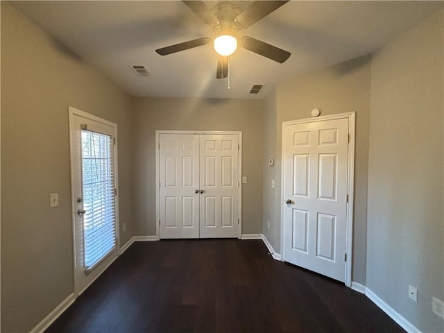 unfurnished bedroom with ceiling fan and dark hardwood / wood-style floors