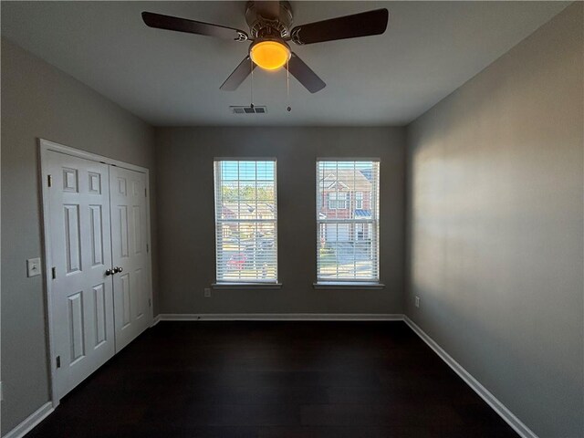 unfurnished room with dark hardwood / wood-style floors and ceiling fan