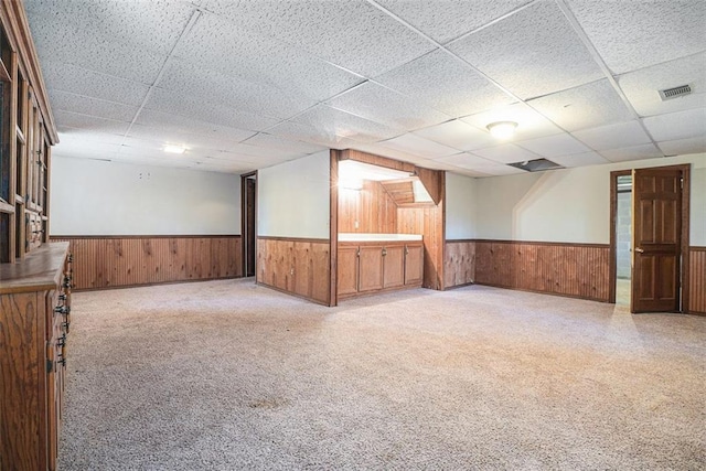 carpeted empty room with a drop ceiling