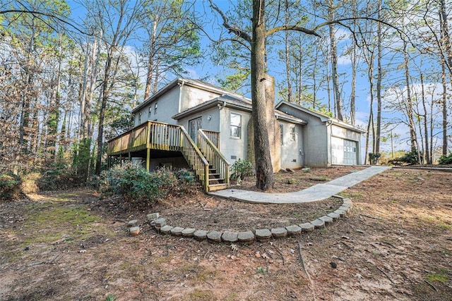 view of property exterior with a garage and a wooden deck