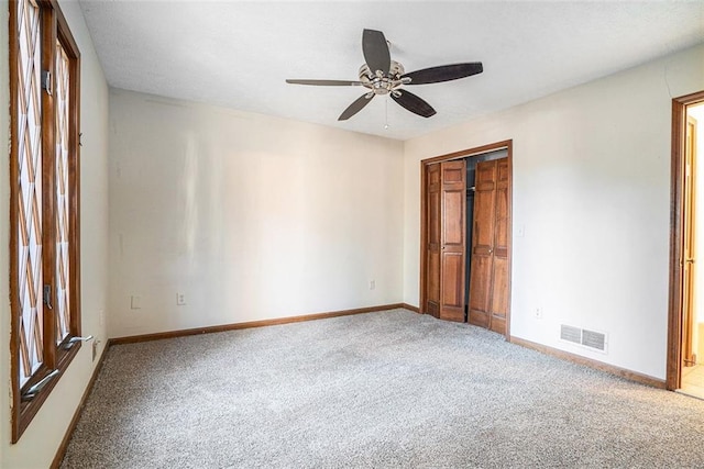 unfurnished bedroom featuring ceiling fan, a closet, and carpet