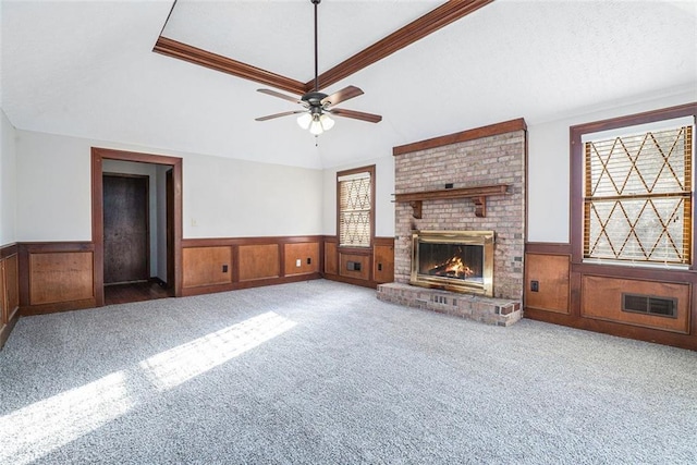 unfurnished living room with light carpet, ceiling fan, a brick fireplace, and ornamental molding