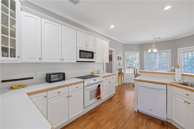 kitchen with white appliances, white cabinetry, and glass insert cabinets