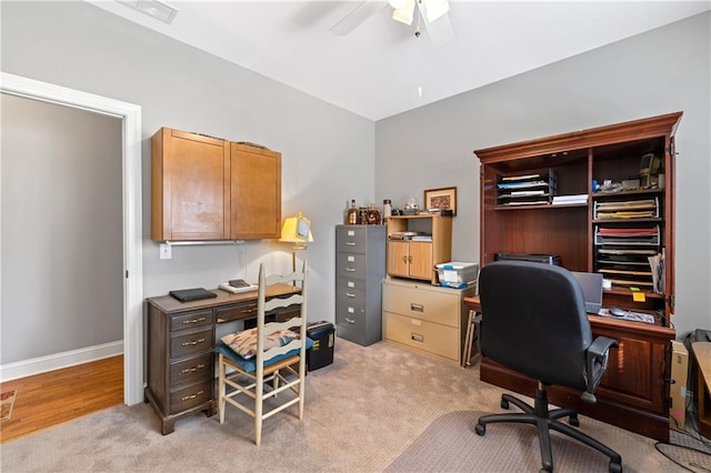 home office featuring light carpet, visible vents, baseboards, and a ceiling fan