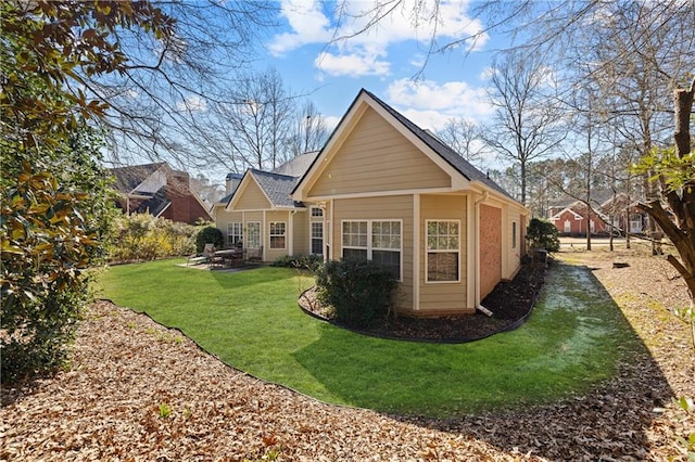 back of house featuring a patio and a yard