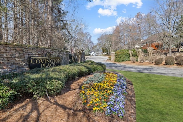 community / neighborhood sign featuring a yard