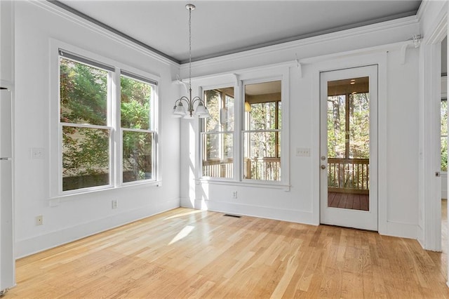 entryway featuring light wood-type flooring, plenty of natural light, and a notable chandelier