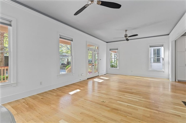 unfurnished living room featuring a healthy amount of sunlight, light wood-type flooring, and crown molding