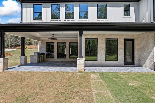 6238 Mount Salem Cir, Flowery Branch, GA 30542 - property entrance featuring board and batten siding, brick siding, a patio, and a lawn