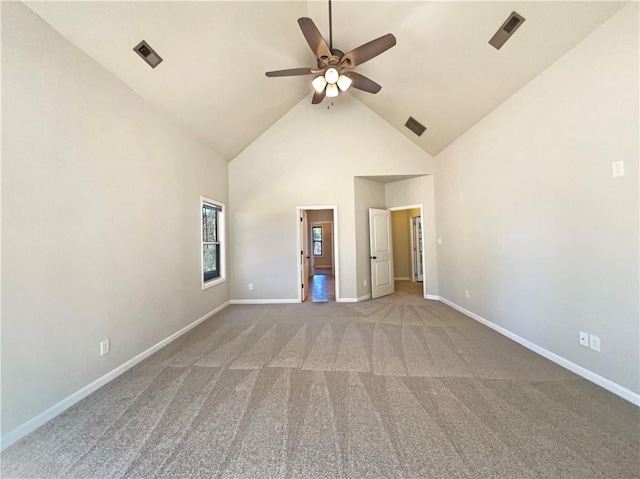 empty room featuring a ceiling fan, visible vents, baseboards, carpet floors, and high vaulted ceiling