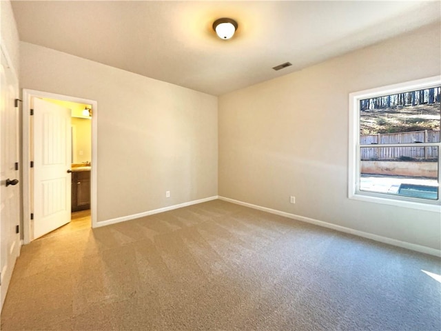 unfurnished room with visible vents, carpet, and baseboards
