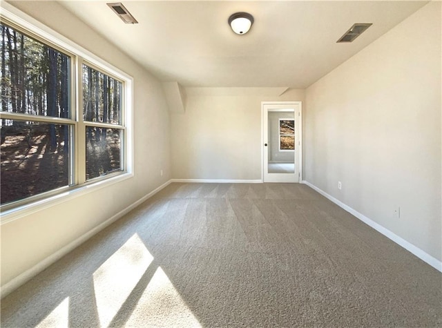 carpeted empty room with plenty of natural light, baseboards, and visible vents