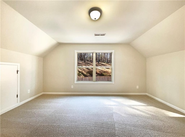 additional living space featuring visible vents, lofted ceiling, carpet floors, and baseboards