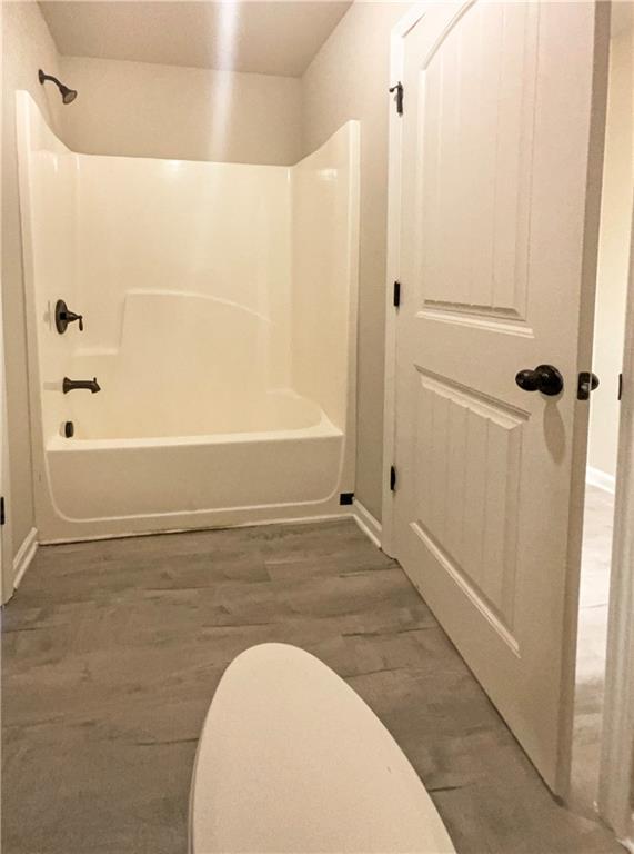 full bath featuring tub / shower combination and wood finished floors