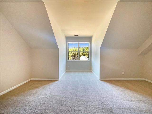 additional living space with baseboards, carpet, and vaulted ceiling