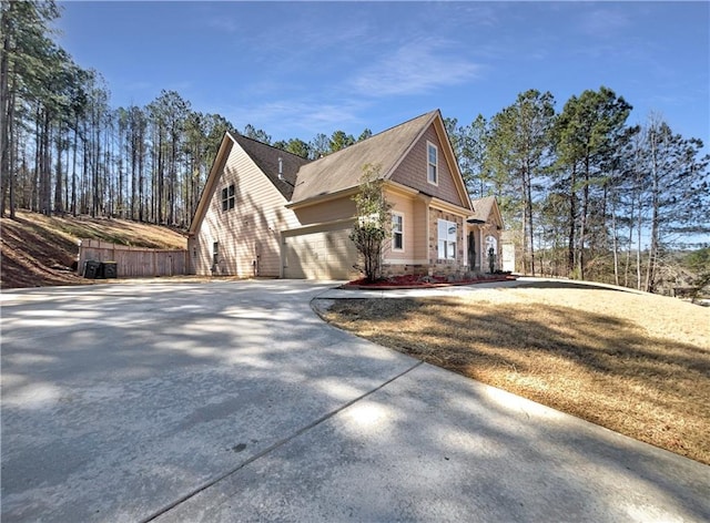 view of side of property with concrete driveway and an attached garage