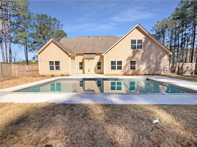 rear view of house featuring a fenced in pool, a patio area, and fence