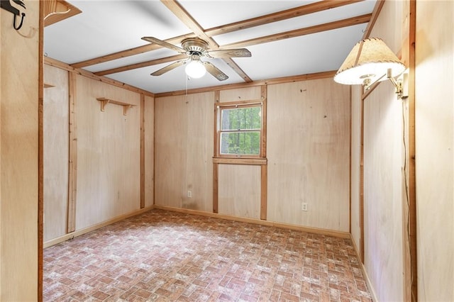 unfurnished room with wooden walls, ceiling fan, brick patterned floor, and baseboards