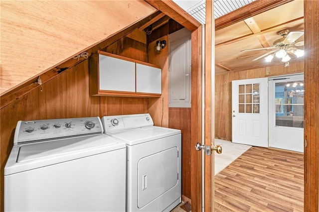 laundry area with washing machine and dryer, wood walls, ceiling fan, light wood finished floors, and cabinet space