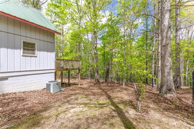 view of yard with a deck and central air condition unit