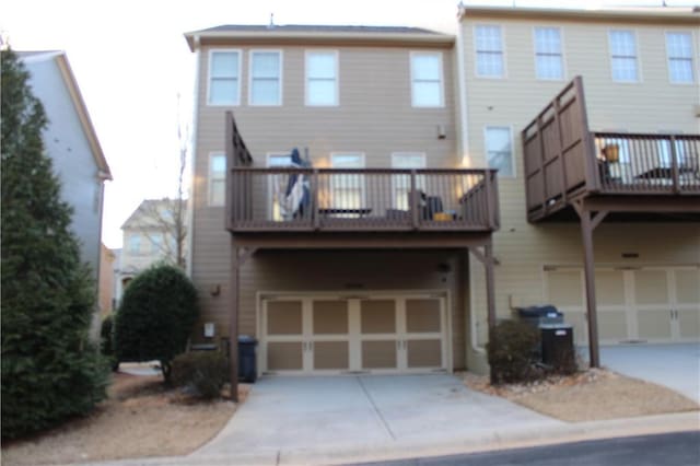 rear view of property with a garage and a balcony