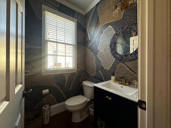 bathroom featuring vanity, crown molding, and toilet