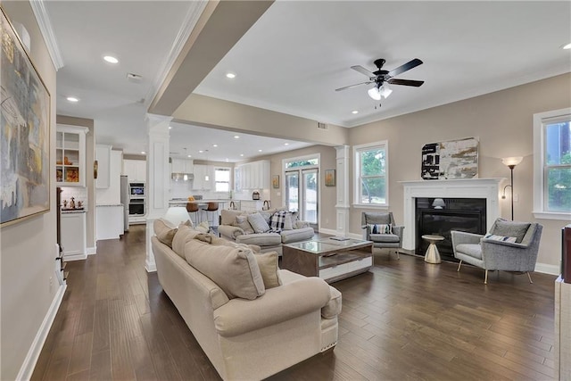 13015 Fox Rd, Alpharetta, GA 30005 - living room featuring ceiling fan, crown molding, dark wood-style floors, ornate columns, and a glass covered fireplace