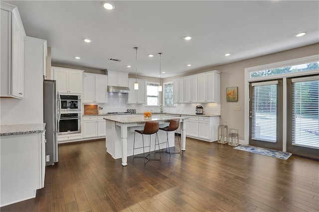 13015 Fox Rd, Alpharetta, GA 30005 - kitchen featuring a kitchen island, white cabinets, decorative backsplash, under cabinet range hood, and stainless steel appliances