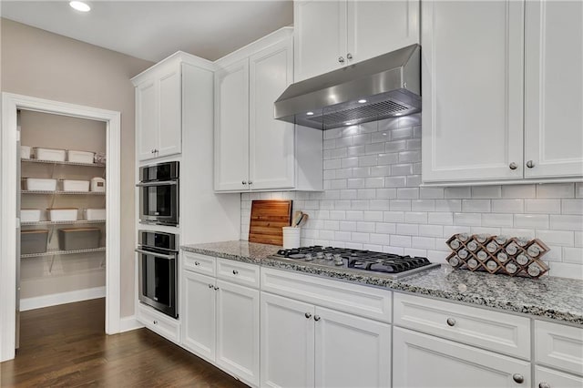 13015 Fox Rd, Alpharetta, GA 30005 - kitchen with ventilation hood, appliances with stainless steel finishes, light stone counters, white cabinetry, and dark wood-style flooring