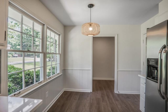 unfurnished dining area with dark wood-style flooring and wainscoting