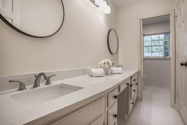 full bath with toilet, double vanity, and tile patterned floors