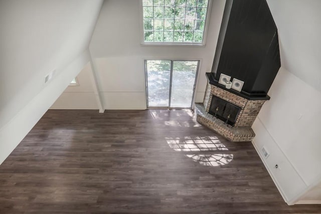 unfurnished living room with a fireplace, wood finished floors, and vaulted ceiling