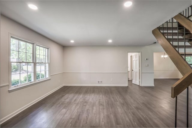 unfurnished living room with dark wood-style flooring, recessed lighting, baseboards, and stairway