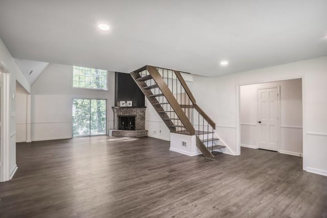 unfurnished living room featuring a fireplace, dark wood-style flooring, stairway, baseboards, and recessed lighting