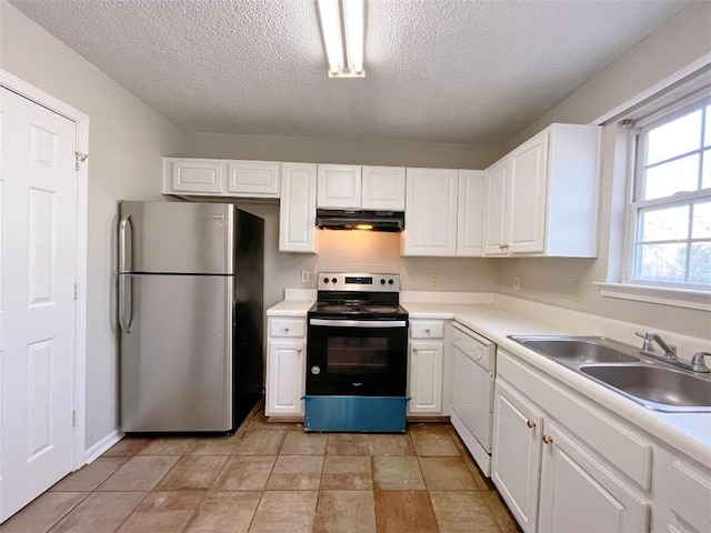 kitchen with appliances with stainless steel finishes, light tile patterned flooring, white cabinets, and sink