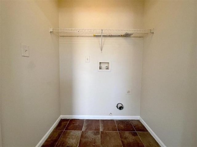 washroom with washer hookup, hookup for a gas dryer, and dark tile patterned flooring