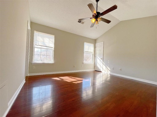 spare room featuring a textured ceiling, lofted ceiling, hardwood / wood-style flooring, and ceiling fan