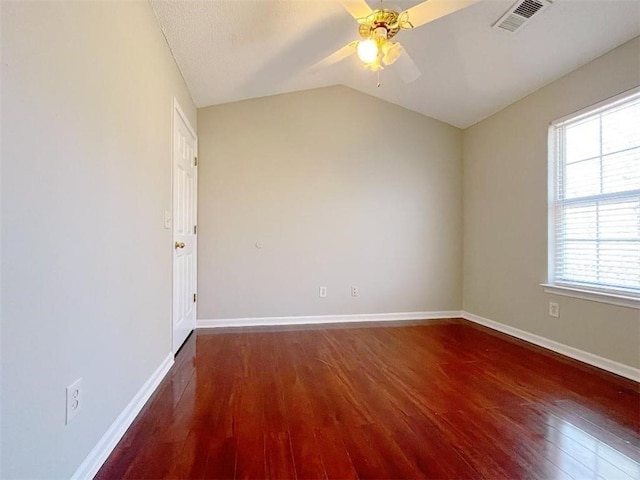 empty room with plenty of natural light, dark hardwood / wood-style floors, and ceiling fan