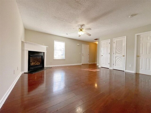 unfurnished living room with ceiling fan, hardwood / wood-style flooring, and a textured ceiling