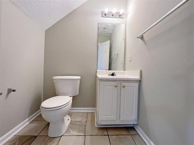 bathroom featuring vanity, tile patterned floors, toilet, a textured ceiling, and lofted ceiling