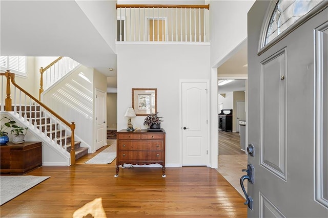 foyer entrance featuring hardwood / wood-style flooring and a towering ceiling