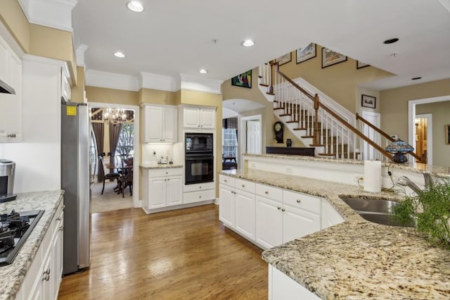 kitchen with light stone countertops, sink, light hardwood / wood-style floors, white cabinets, and stainless steel refrigerator