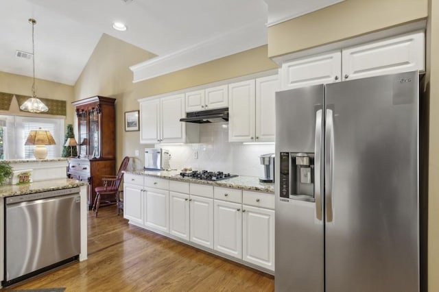 kitchen featuring lofted ceiling, hanging light fixtures, stainless steel appliances, light wood-type flooring, and white cabinetry