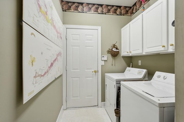 laundry room with light tile patterned floors, cabinets, and washer and clothes dryer