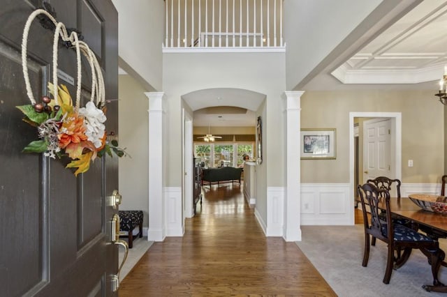 foyer entrance with dark hardwood / wood-style flooring, ceiling fan, and decorative columns