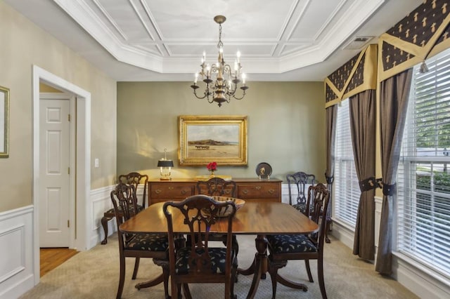 dining room with ornamental molding, light colored carpet, and an inviting chandelier