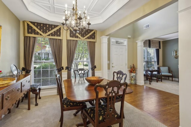 dining area with ornamental molding, a chandelier, wood-type flooring, and decorative columns